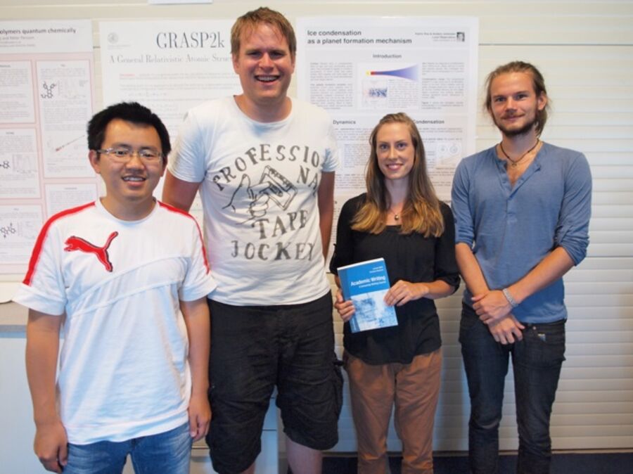 The poster prize winner and the three runners up in front of three posters