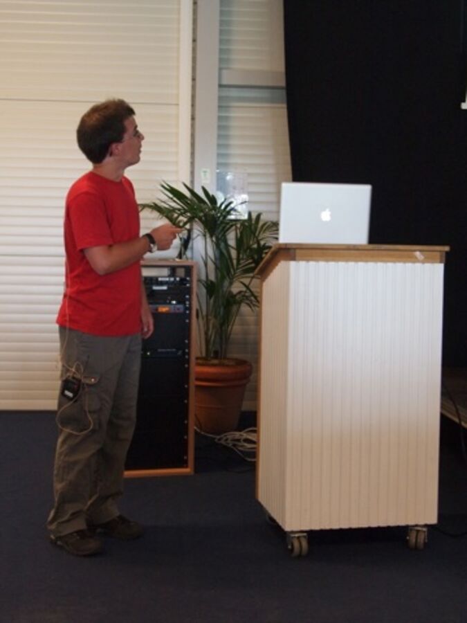 A speaker making a point on the screen with a laser pointer