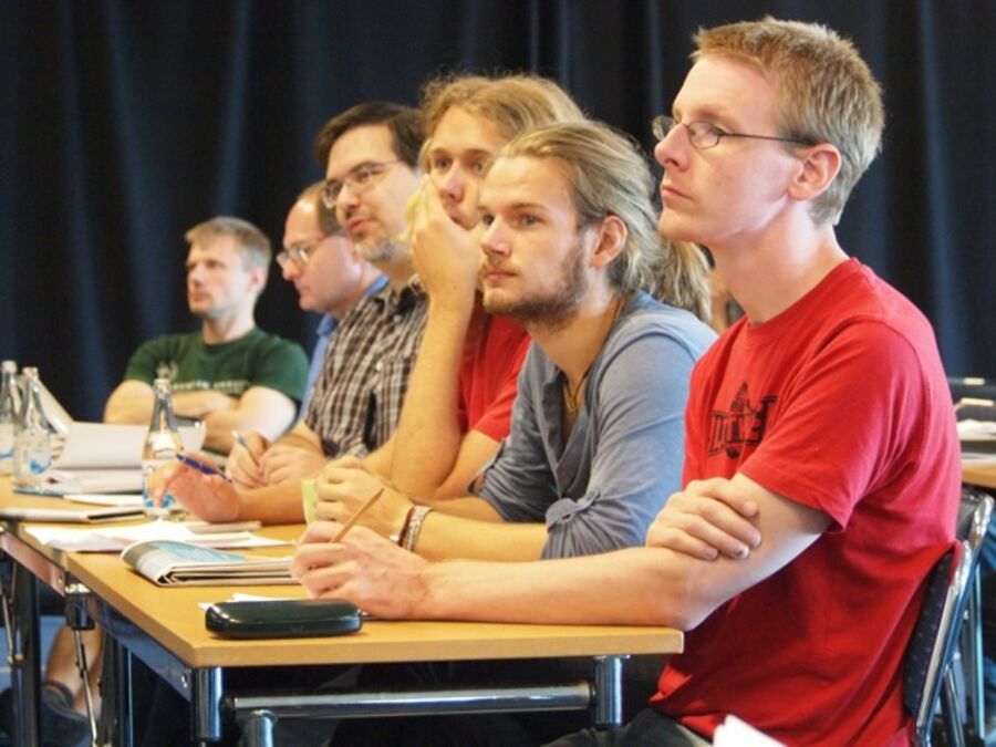 A row of participants listening to a speaker