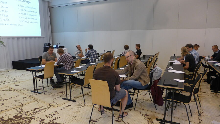 Participants discussing in groups of two in the lecture hall