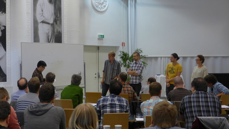 The five members of a group giving a presentation at a whiteboard