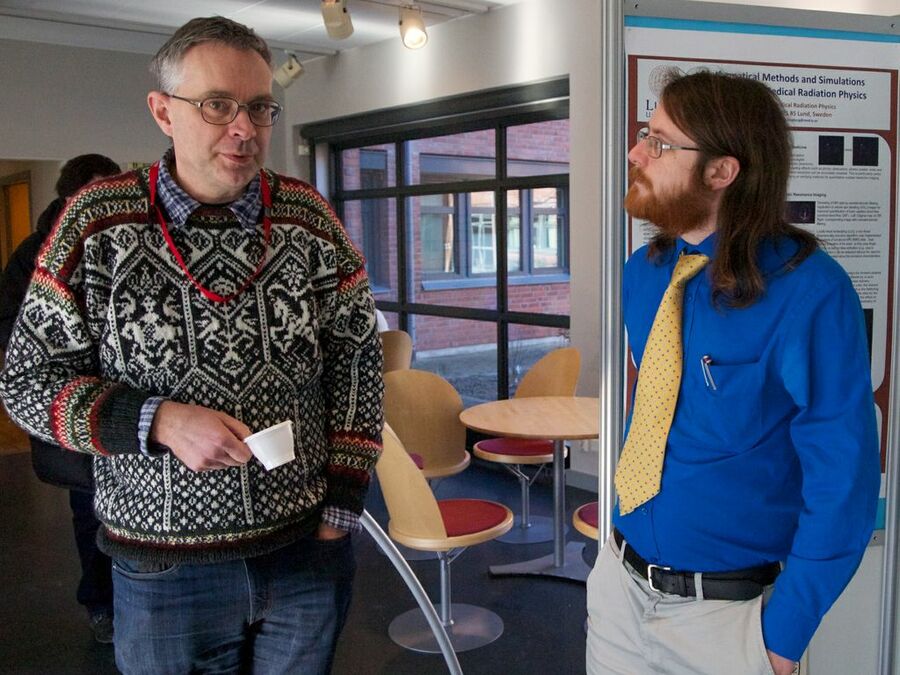 Two participants discussing in front of posters.