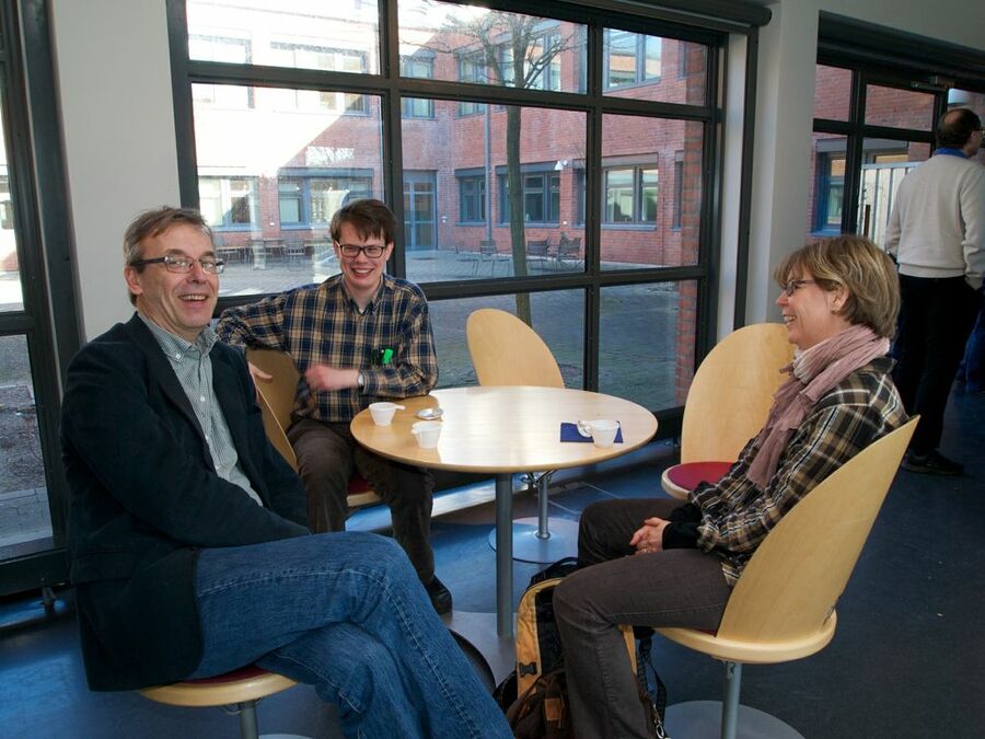 Three participants sitting around a table at a break.