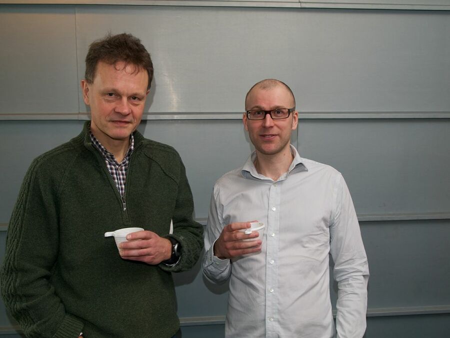 Two participants with cups at a coffee break.