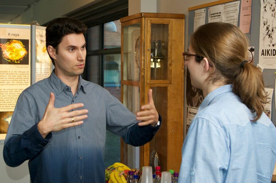 Two particpants involved in a discussion at a break.