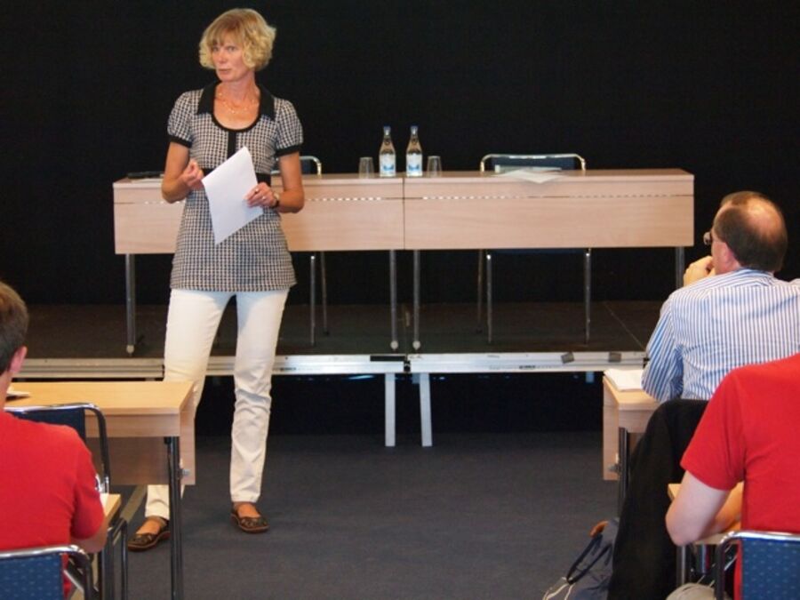 A speaker with a sheet of paper in her hand